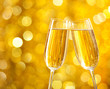 Two glasses of champagne with lights in the background.