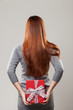 Woman hiding a gift behind her back