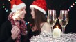 Xmas party scene, wine glasses and candle at foreground
