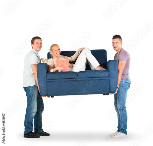 Photo: Two men carrying a couch with a woman smiling Two men carrying a couch with a woman smiling