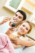 Cheerful young couple watching TV together