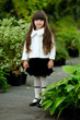 portrait of little girl outdoors in the style of gardener