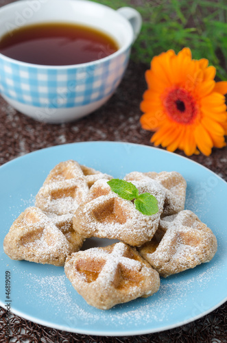 Photo: Waffles sprinkled with powdered sugar and black tea selective fo Waffles sprinkled with powdered sugar and black tea selective fo