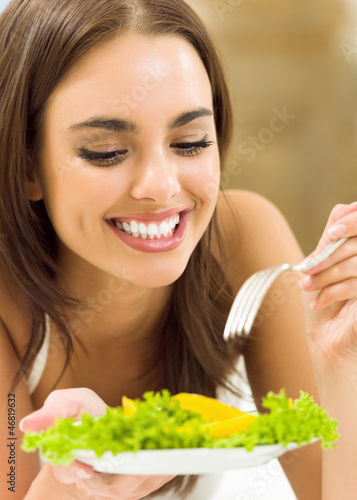 Photo: Young woman with salad, at home Young woman with salad, at home