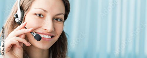 Photo: Cheerful smiling support phone operator at office Cheerful smiling support phone operator at office