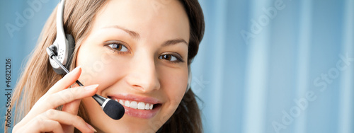 Photo: Cheerful smiling support phone operator at office Cheerful smiling support phone operator at office