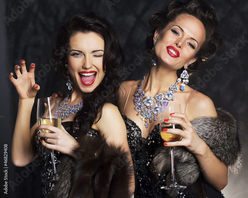 Photo: Young women in black elegant dress with champagne - nightlife Young women in black elegant dress with champagne - nightlife
