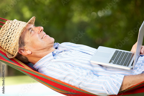 Photo: Senior Man Relaxing In Hammock With Laptop Senior Man Relaxing In Hammock With Laptop