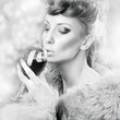 Glamorous woman in fur drinking wine