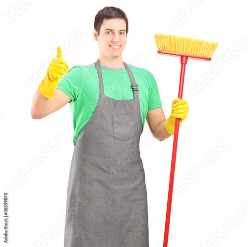 Photo: A male cleaner posing with brush and giving thumb up A male cleaner posing with brush and giving thumb up