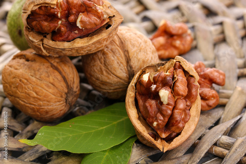 Photo: walnuts with green leaves, on wicker background walnuts with green leaves, on wicker background