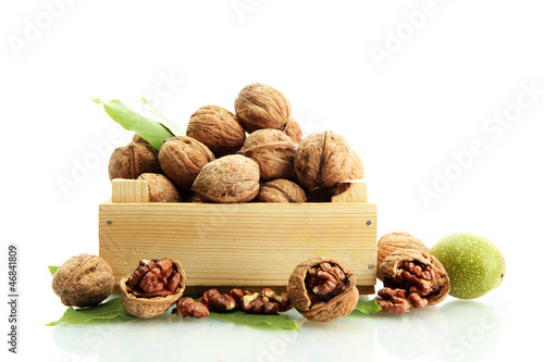 Photo: walnuts with green leaves in woooden crate, isolated on white walnuts with green leaves in woooden crate, isolated on white