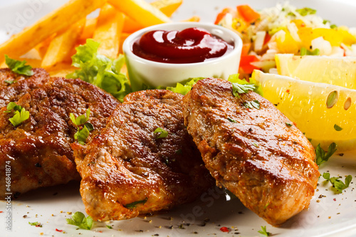 Photo: Grilled steaks, French fries and vegetables Grilled steaks, French fries and vegetables