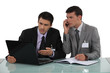 Two businessmen arguing at a desk