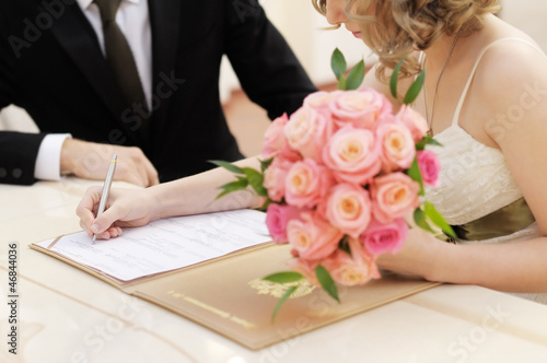 Photo: Bride signing marriage license or wedding contract Bride signing marriage license or wedding contract