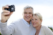 Senior couple taking picture of themselves outside