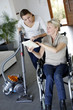 Young woman helping disabled lady at home