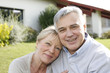 Smiling senior couple sitting in garden