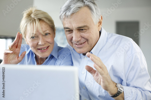 Photo: Senior couple connected with family on internet Senior couple connected with family on internet