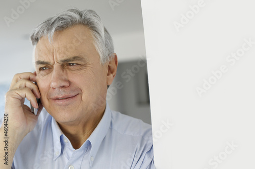 Photo: Aged man talking on mobile phone Aged man talking on mobile phone
