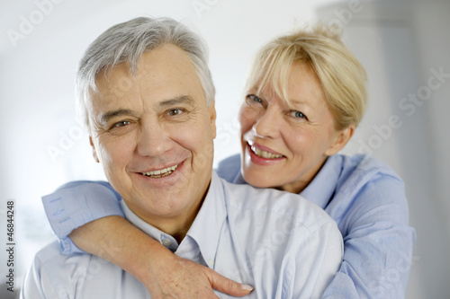Photo: Portrait of cheerful senior couple at home Portrait of cheerful senior couple at home