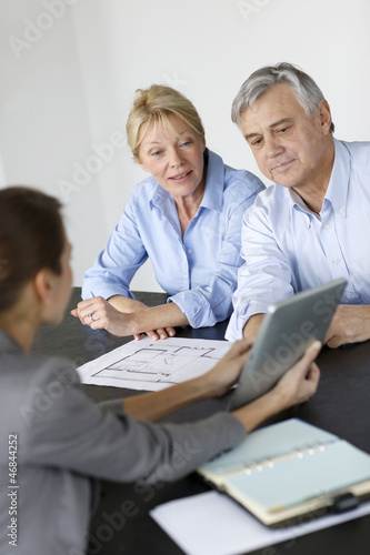 Photo: Senior couple meeting architect for building project Senior couple meeting architect for building project