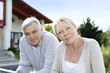 Smiling senior couple standing in home garden