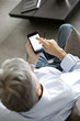 Back view of senior man using smartphone