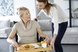 Young woman helping senior woman at home