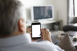 Back view of senior man using smartphone