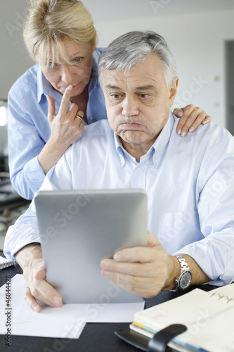 Photo: Senior couple trying to figure out tax declaration Senior couple trying to figure out tax declaration