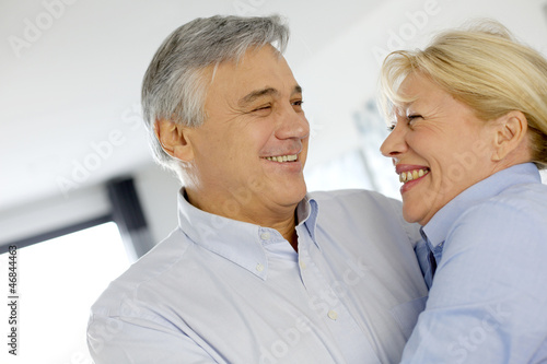 Photo: Portrait of cheerful senior couple at home Portrait of cheerful senior couple at home