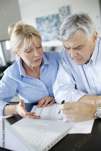 Photo: Senior couple inquiring bank website for help Senior couple inquiring bank website for help