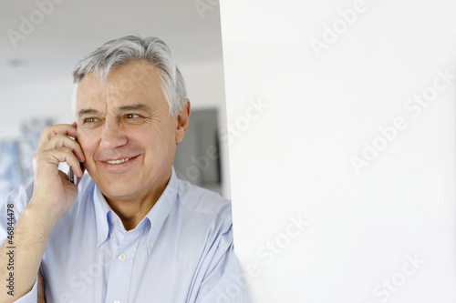 Photo: Aged man talking on mobile phone Aged man talking on mobile phone