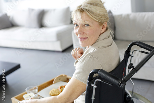 Photo: Senior woman in wheelchair holding lunch tray Senior woman in wheelchair holding lunch tray