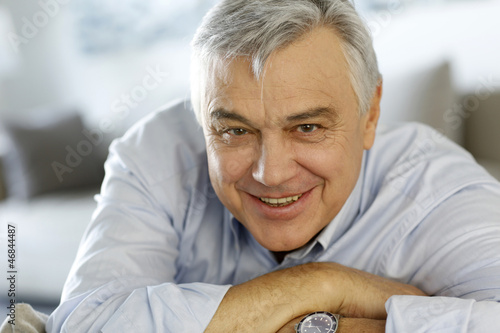 Photo: Portrait of senior man relaxing in sofa at home Portrait of senior man relaxing in sofa at home
