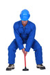 Landscape picture of plumber with plunger