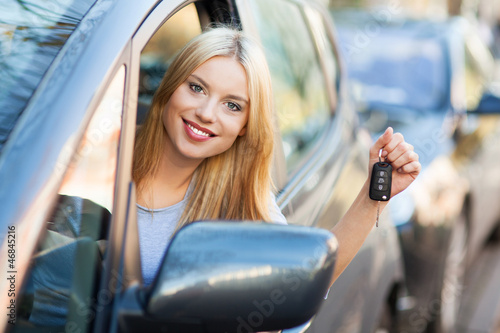 Photo: Young woman showing car key Young woman showing car key