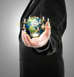 Foto: Business man holding the small world in his hands against white Business man holding the small world in his hands against white