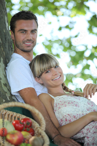 Photo: Couple in the field with fruit basket Couple in the field with fruit basket