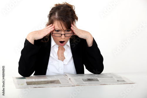 Photo: Shocked woman reading the newspaper Shocked woman reading the newspaper