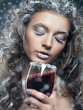 Portrait of young woman with snow make-up with a glass of wine.