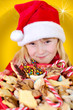 Kleinkind als Weihnachtsmann mit Weihnachtsteller