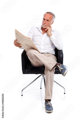 Photo: Casual senior man with newspaper, pondering Casual senior man with newspaper, pondering