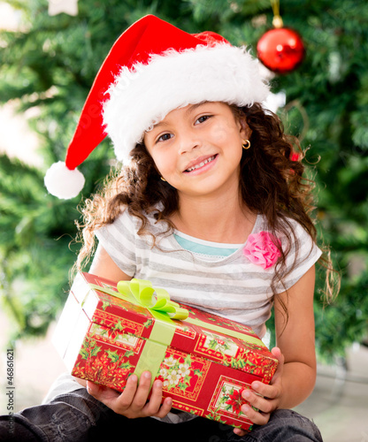 Photo: Girl holding a Christmas gift Girl holding a Christmas gift