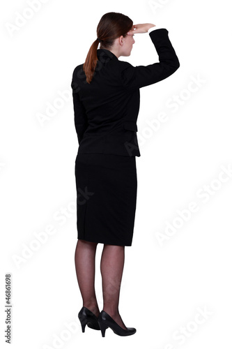 Photo: businesswoman seen from behind looking in the distance businesswoman seen from behind looking in the distance