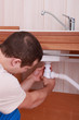 Plumber screwing siphon