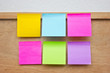 Photo: Six colorful sticky notes on wooden board. Six colorful sticky notes on wooden board.
