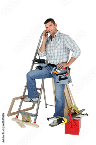 Photo: Carpenter stood by equipment making call Carpenter stood by equipment making call