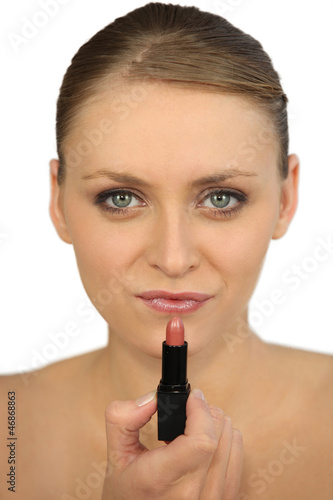 Photo: Woman applying lipstick Woman applying lipstick